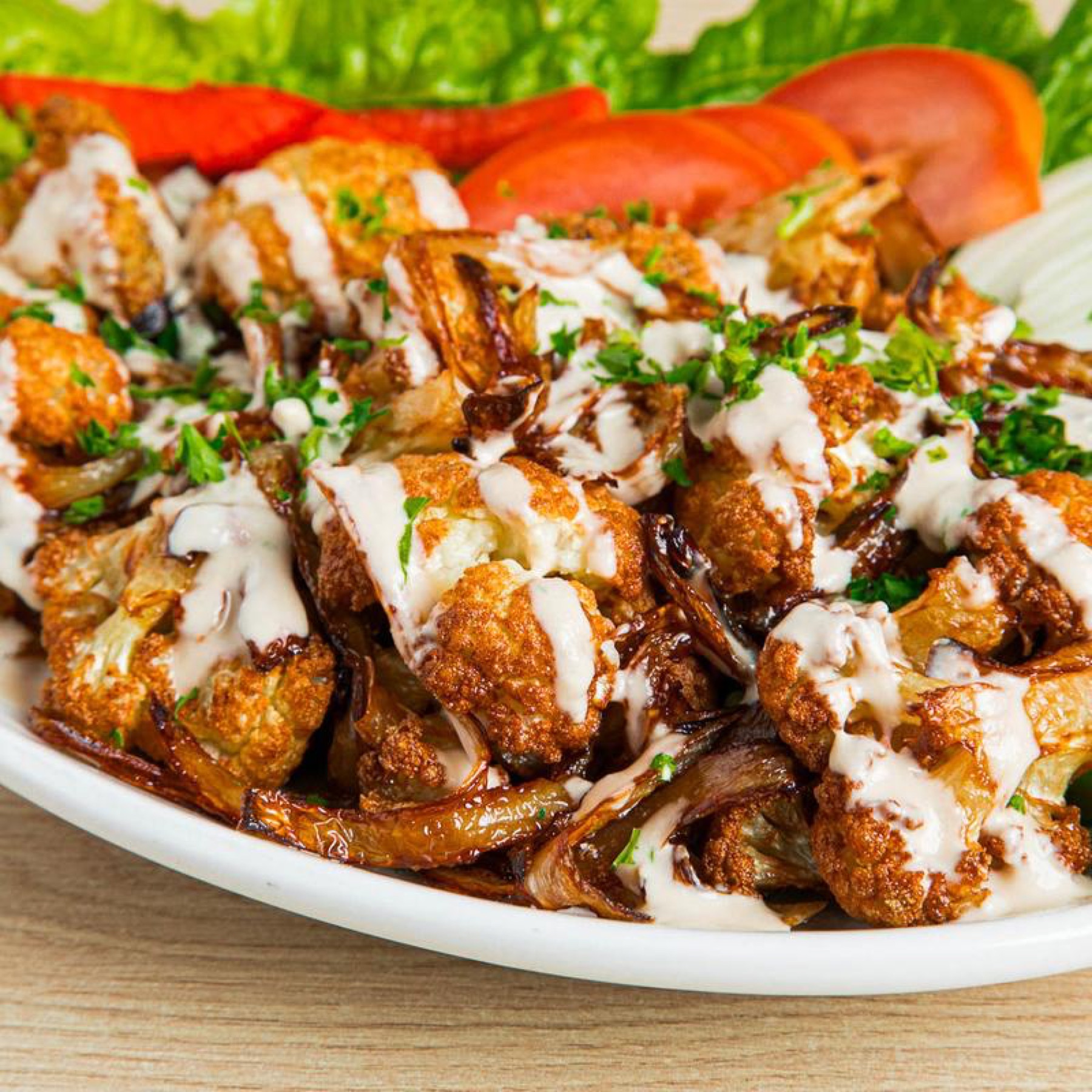 Fried cauliflower topped with tahini and parsley