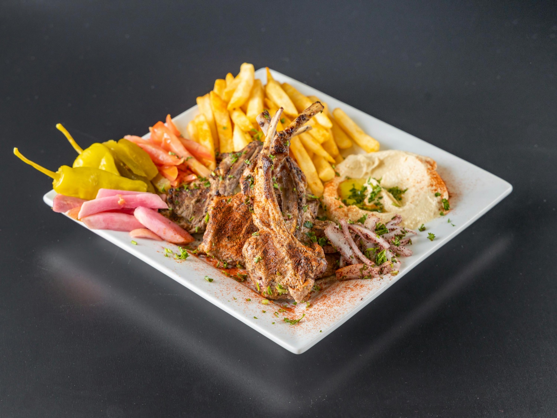 Lamb chops with fries, pickles and hummus