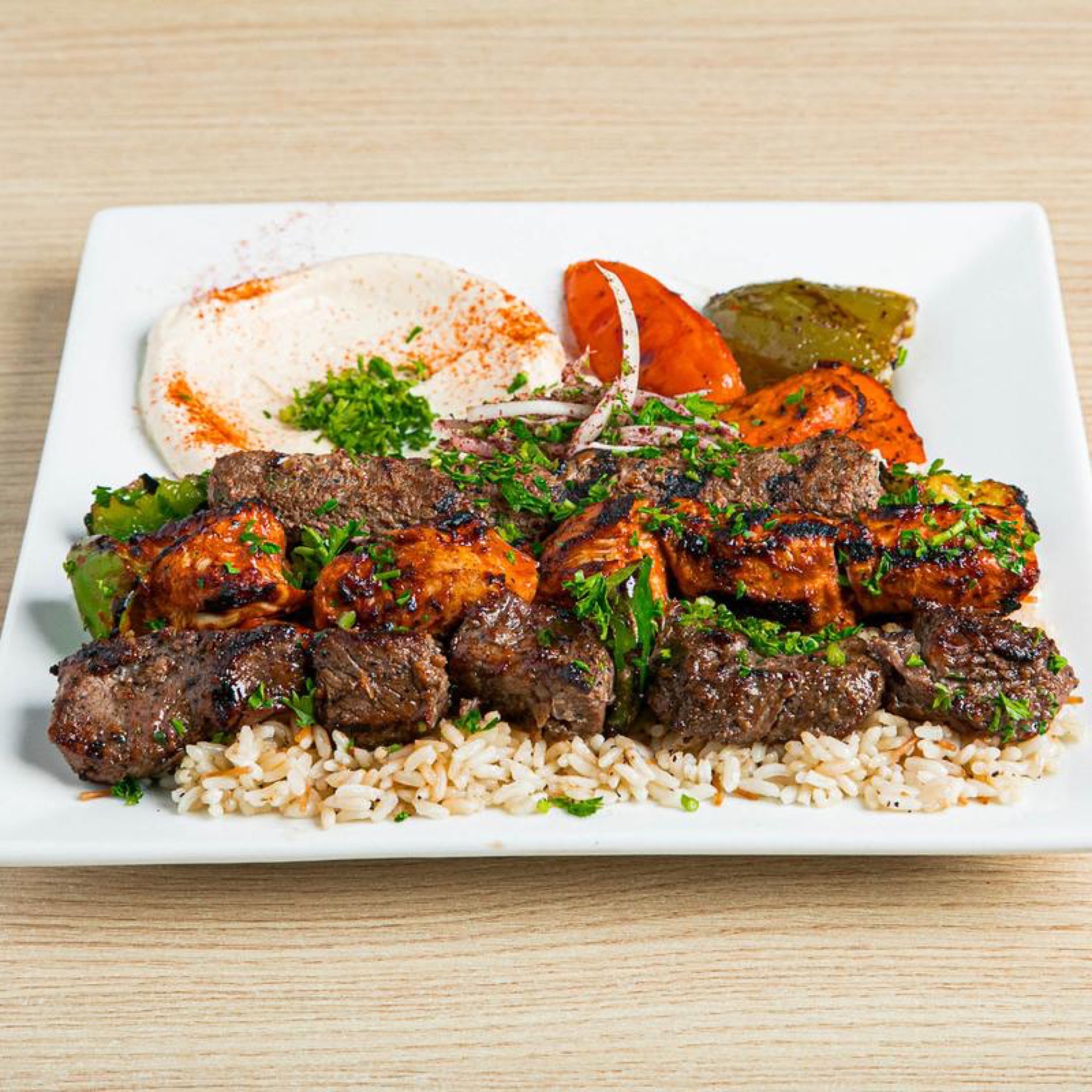 Shish combo with beef, chicken kabob and kafta over rice with hummus and grilled tomato