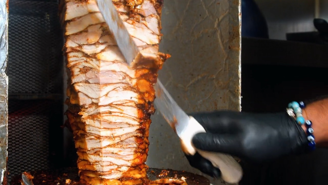 Chicken shawarma being carved from the spit